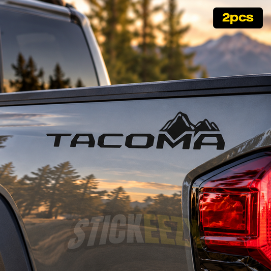 Toyota Tacoma lettering vinyl decal installed on the upper rear corner of a pickup truck bed near the taillight